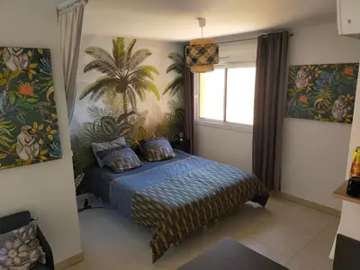 a bedroom with a bed and a palm tree mural at Sanguinaires in Ajaccio