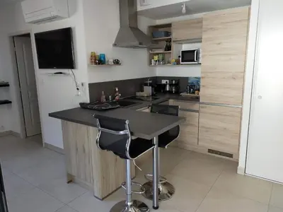 a kitchen with a black counter and a refrigerator at Sanguinaires in Ajaccio