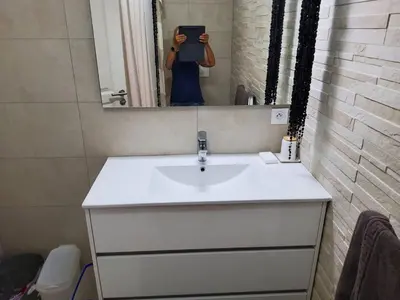 a woman taking a picture of a sink in a bathroom at Sanguinaires in Ajaccio