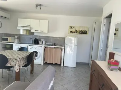 a kitchen with a table and a white refrigerator at Village Cargèse 2 in Cargèse