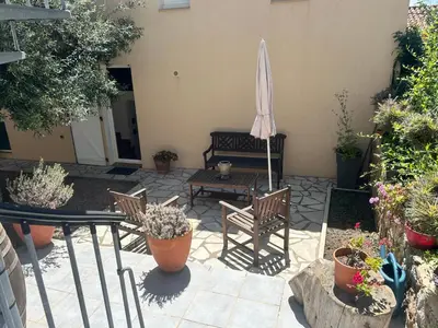 a patio with a table and chairs and an umbrella at Village Cargèse 2 in Cargèse