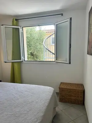 a bedroom with a bed and a large window at Village Cargèse 2 in Cargèse