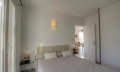 a white bedroom with a large bed with two pillows at Idéal emplacement Cargese 3 in Cargèse
