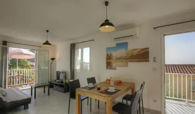 a living room with a wooden table and a dining room at Idéal emplacement Cargese 3 in Cargèse