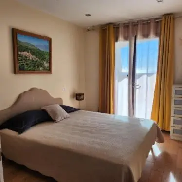 a bedroom with a large bed and a large window at Chambre Shelby vue mer avec kitchenette in Porto-Vecchio