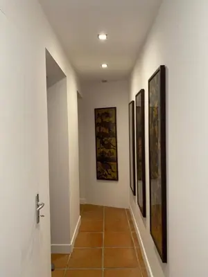 a hallway with four paintings on the walls at Chambre Shelby vue mer avec kitchenette in Porto-Vecchio