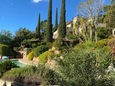 a garden with trees and a house in the background at Chambre Shelby vue mer avec kitchenette in Porto-Vecchio