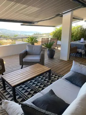 a patio with a couch and a table and chairs at Charmant T3 5 min de porticcio in Porticcio