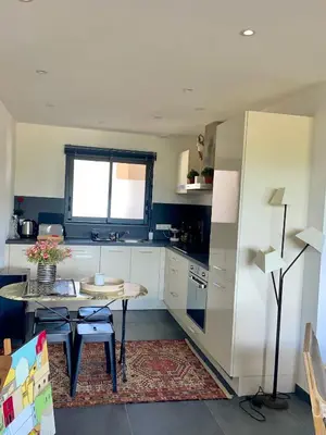 a kitchen with a small table and a window at Charmant T3 5 min de porticcio in Porticcio