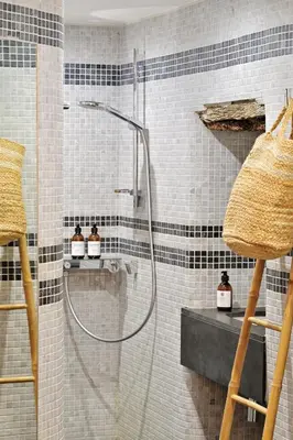 a shower in a bathroom with black and white tiles at Résidence Mademoiselle Joséphine in Ajaccio