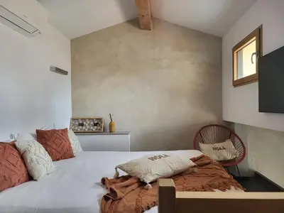 a bedroom with a white bed with a pillow on it at Résidence Mademoiselle Joséphine in Ajaccio