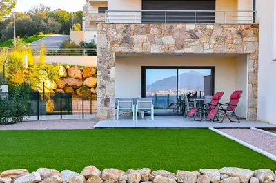 a patio with chairs and a table on a balcony at T3 vue mer 100 m2 de jardin 'D' in Pietrosella