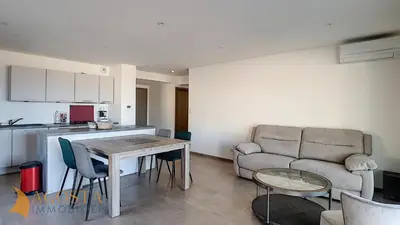 a kitchen and a living room with a table and a couch at T3 vue mer 100 m2 de jardin 'D' in Pietrosella