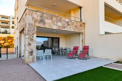 a patio with chairs and a table in a building at T3 vue mer 100 m2 de jardin 'D' in Pietrosella