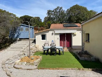a small yard with a table and green grass at Proche Ajaccio maisonnette indépendante 4 personnes au calme in Alata