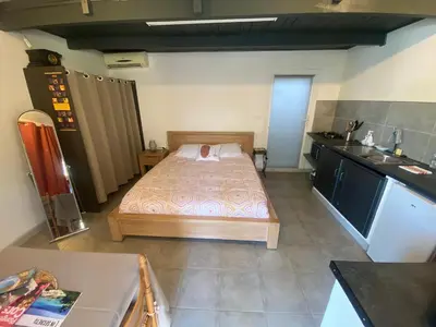 a small bedroom with a bed and a kitchen at Proche Ajaccio maisonnette indépendante 4 personnes au calme in Alata
