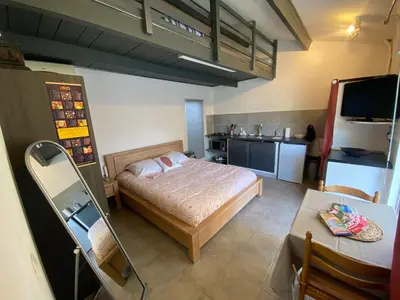 a small bedroom with a bed and a kitchen at Proche Ajaccio maisonnette indépendante 4 personnes au calme in Alata
