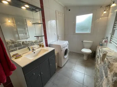 a bathroom with a sink and a washing machine at Proche Ajaccio maisonnette indépendante 4 personnes au calme in Alata