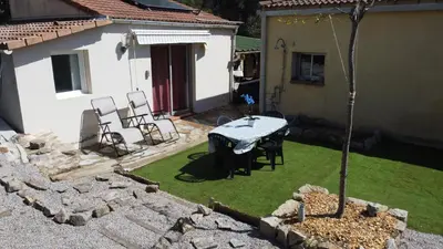 a patio with a table and chairs in a yard at Proche Ajaccio maisonnette indépendante 4 personnes au calme in Alata