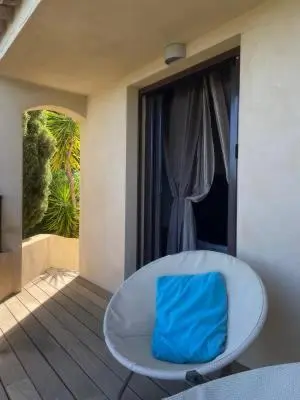 a blue bag sitting on a white chair on a balcony at La chambre d'Aphrodite avec jacuzzi vue mer in Porto-Vecchio