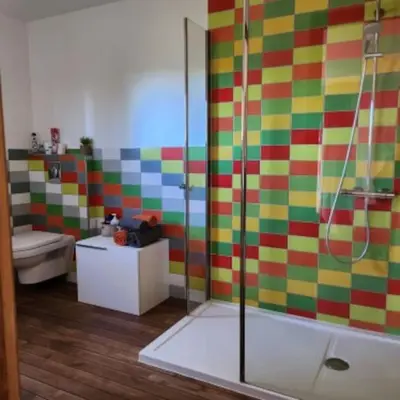 a colorful bathroom with a shower and a sink at La chambre d'Aphrodite avec jacuzzi vue mer in Porto-Vecchio