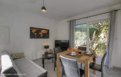 a living room with a table and a couch at Idéal logement Cargese 4 in Cargèse