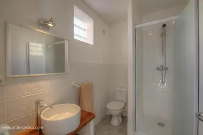 a white bathroom with a sink and a toilet at Idéal logement Cargese 4 in Cargèse