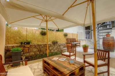 a patio with a table and chairs and an umbrella at Idéal logement Cargese 4 in Cargèse