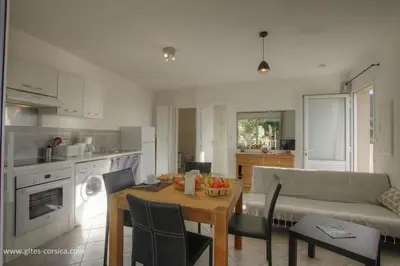 a kitchen and living room with a table and a couch at Idéal logement Cargese 4 in Cargèse