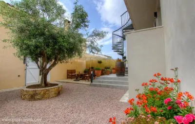 a courtyard with a tree in the middle of a building at Idéal logement Cargese 4 in Cargèse
