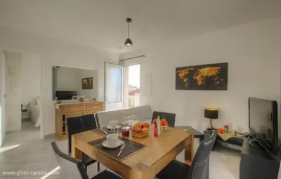 a living room with a wooden table and chairs at Idéal logement Cargese 4 in Cargèse