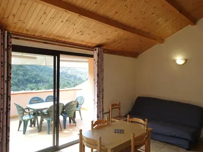 a living room with a couch and a table and chairs at Apartment Residence Cabanaccia 3 Pieces 4 Pers by Interhome in Serriera