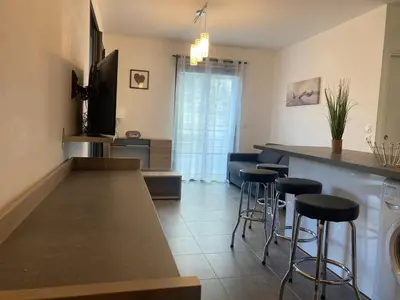 a kitchen with a counter and bar stools at T2 standing Ajaccio in Ajaccio