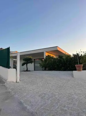 a large building with a tree in front of it at Villa luxe avec piscine et belle vue mer in Pietrosella