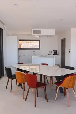 a dining room with a table and chairs in a kitchen at Villa luxe avec piscine et belle vue mer in Pietrosella