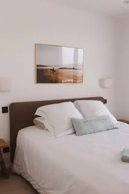a bedroom with a white bed with a picture on the wall at Villa luxe avec piscine et belle vue mer in Pietrosella