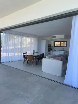 a living room with a couch and a table at Villa luxe avec piscine et belle vue mer in Pietrosella