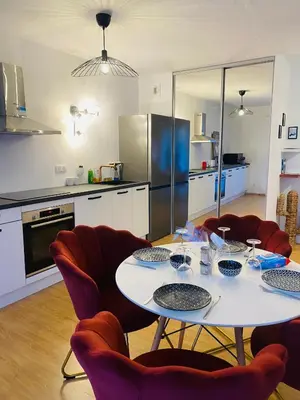 a kitchen with a table and chairs and a kitchen with a refrigerator at Lisandrina in Ajaccio
