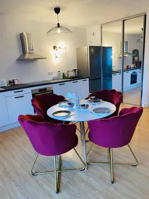 a kitchen with a table and purple chairs in a room at Lisandrina in Ajaccio