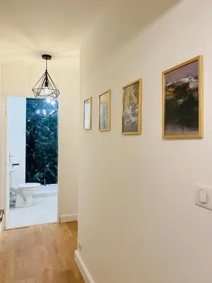 a room with a white wall with paintings on it at Lisandrina in Ajaccio