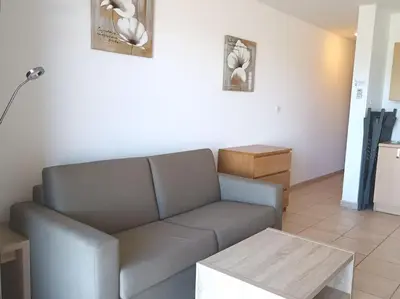 a living room with a couch and a table at CHEZ ADRIEN 108-Appartement magnifique vue mer piscine chauffée in Serra-di-Ferro