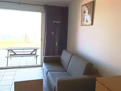 a living room with a couch and a large window at CHEZ ADRIEN 108-Appartement magnifique vue mer piscine chauffée in Serra-di-Ferro