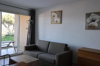 a living room with a couch and a table at CHEZ ADRIEN 108-Appartement magnifique vue mer piscine chauffée in Serra-di-Ferro