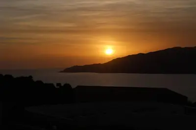 a sunset over the ocean with the sun in the sky at CHEZ ADRIEN 108-Appartement magnifique vue mer piscine chauffée in Serra-di-Ferro