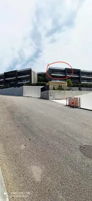 a building with a red ring on the side of a road at La Civita Piétrosella in Pietrosella