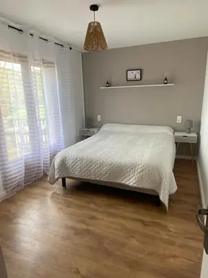 a bedroom with a bed and a large window at Appartement proche du départ du GR20 in Calenzana