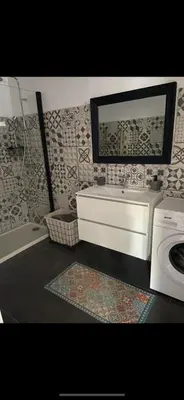 a bathroom with a sink and a washing machine at Appartement proche du départ du GR20 in Calenzana
