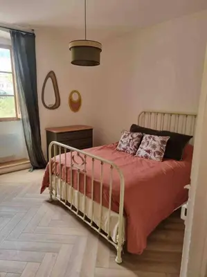 a bedroom with a bed with a red comforter at Appartement au cœur de la ville in Corte