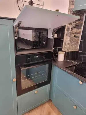 a kitchen with a microwave oven and a stove at Appartement au cœur de la ville in Corte