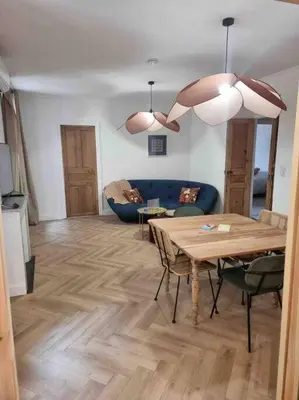 a living room with a table and a blue couch at Appartement au cœur de la ville in Corte